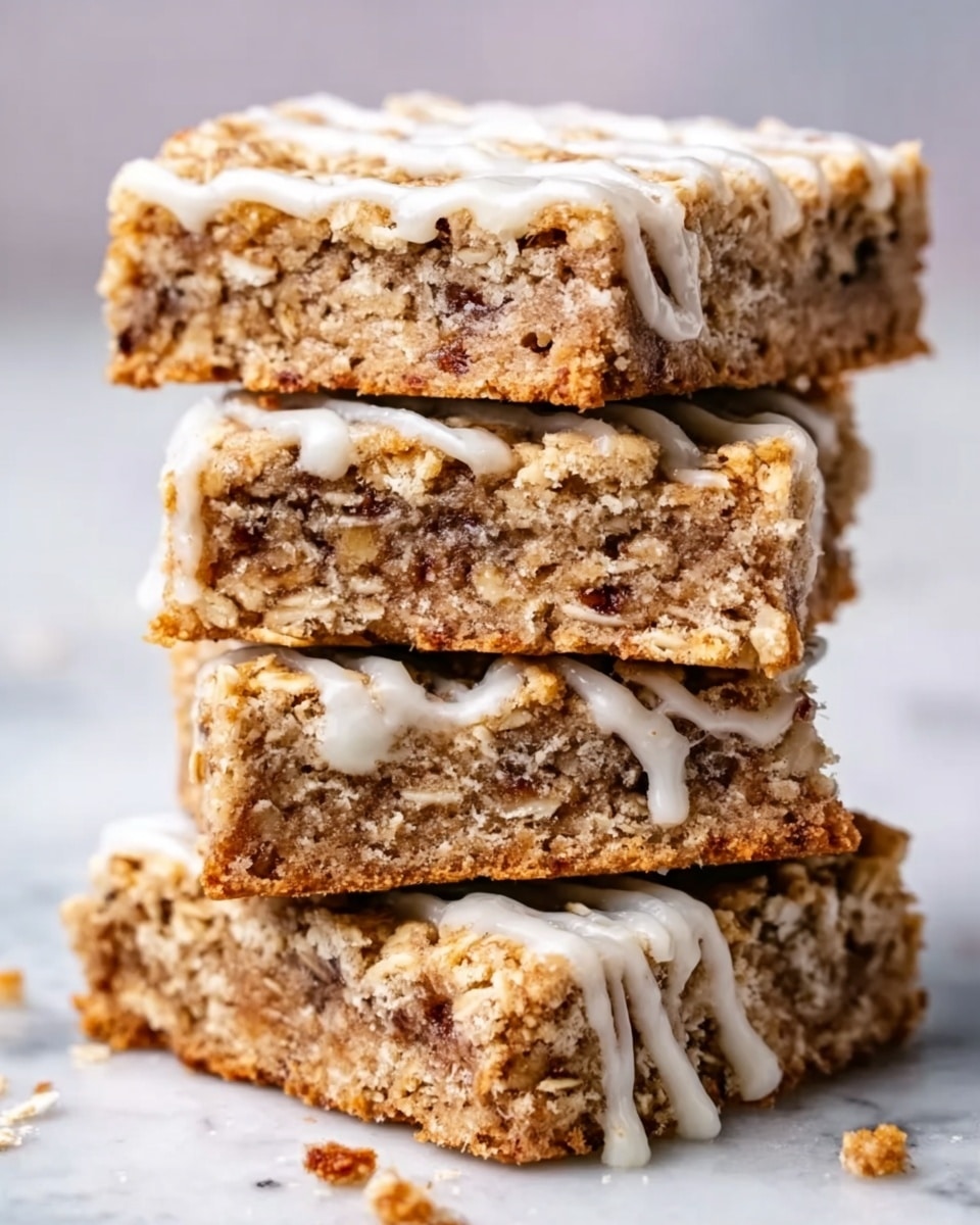The image shows a stack of four thick oat bars with a rough, crumbly texture. Each bar has a golden-brown color from the baked oats and is topped with a drizzled white icing that adds a shiny contrast. The layers are clearly visible, with oats and bits of nuts or dried fruit mixed throughout. The bars are stacked unevenly on a white marbled surface, creating a rustic and cozy look. photo taken with an iphone --ar 4:5 --v 7